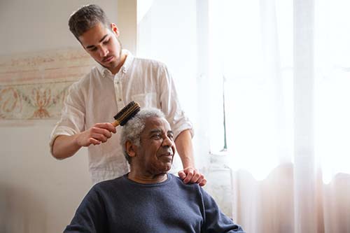 Socio coiffeur coiffant une personne âgée